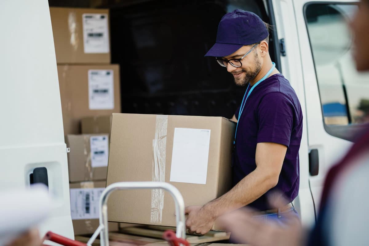 Delivery driver unloads a package from a truck