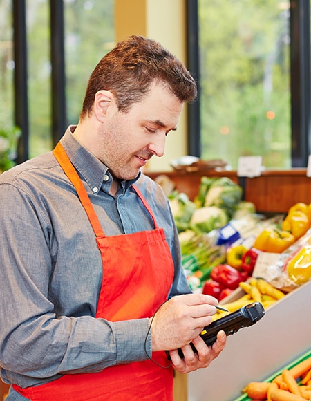 grocery store employee using mobile device